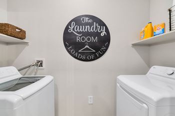 the laundry room has a washer and dryer and a sign on the wall at Weylyn Luxury Apartments, Arizona, 85339